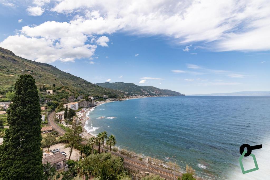 - une vue sur la plage avec des arbres et l'océan dans l'établissement HOTIDAY Taormina Mare, à Taormine