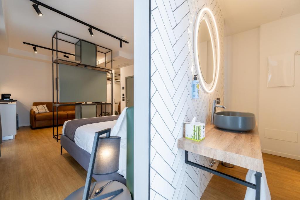 une salle de bain avec un lit et un lavabo dans une chambre dans l'établissement Meg Lifestyle Hotel & Apartaments, à Riccione