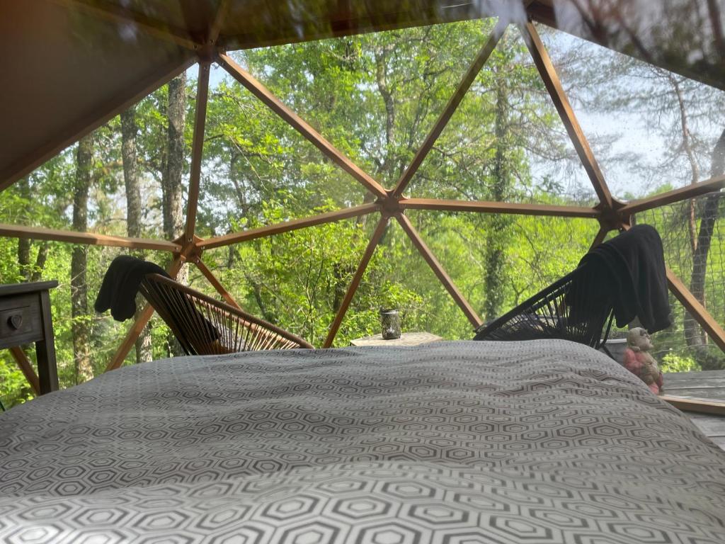 - une chambre avec un lit et deux chaises dans une yourte dans l'établissement Arborea, nuits insolites au cœur de la forêt, à Montignac 26 autres photos