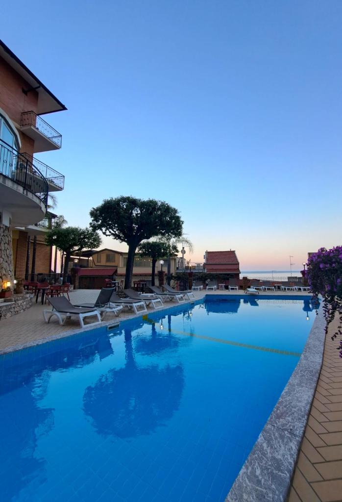 une grande piscine avec de l'eau bleue dans l'établissement Hotel Corallo, à Taormine