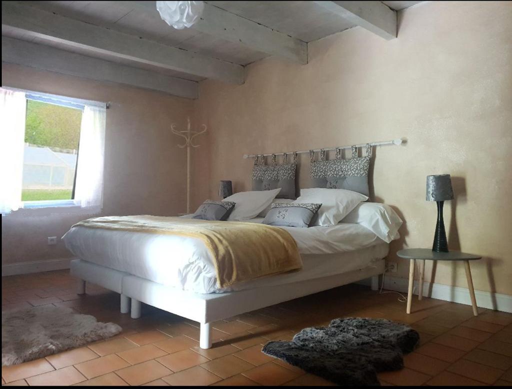 une chambre avec un grand lit blanc dans une pièce dans l'établissement Seuls en Pleine Nature - Gîte la Côte Blanche, à Puygaillard-de-Quercy 37 autres photos