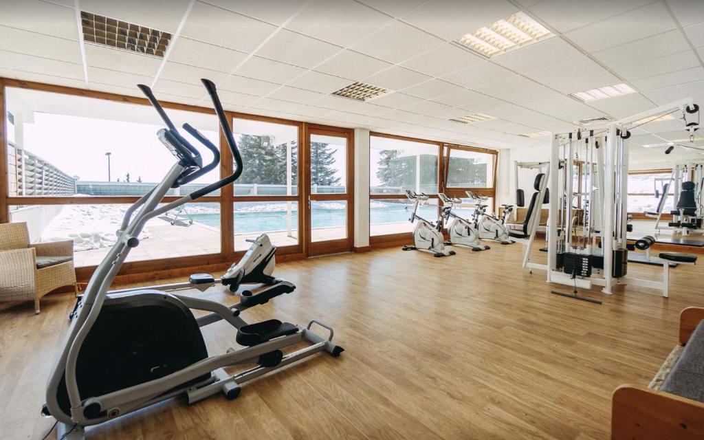 une salle de sport avec tapis de course et machines elliptiques dans l'établissement Charmant appartement confortable pour 6 personnes 40m2 pied pistes, Piscine, wifi, parking, à Chamrousse
