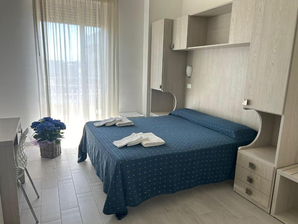 une chambre avec un lit bleu avec des serviettes dessus dans l'établissement Hotel Concorde, à Bellaria-Igea Marina