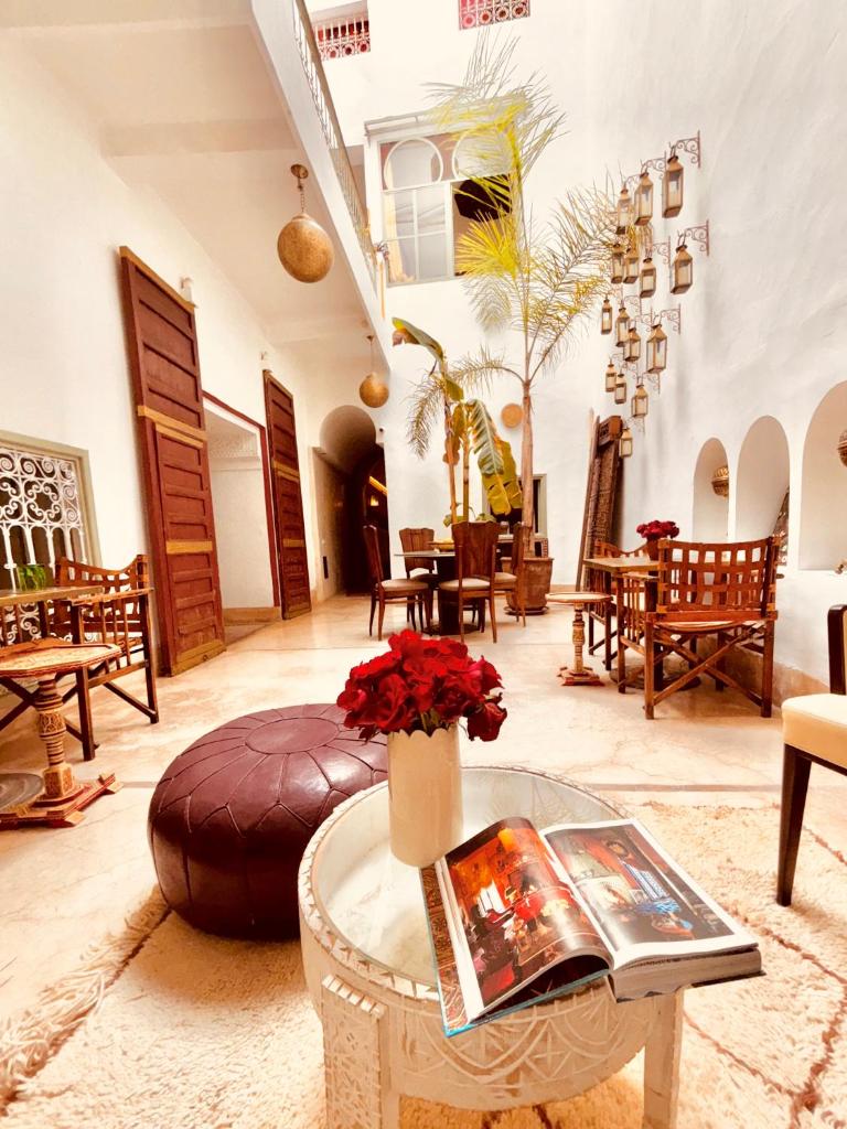 un salon avec une table avec des fleurs dessus dans l'établissement Riad la Cigale, à Marrakech