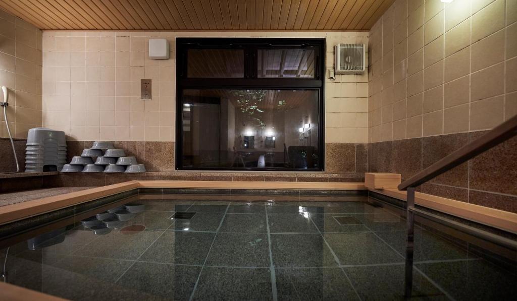 - une piscine dans une chambre avec fenêtre dans l'établissement Sarusawaike Yoshidaya, à Nara