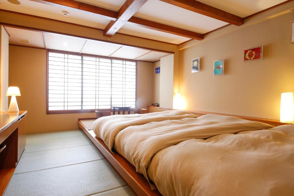 une chambre avec un grand lit et une fenêtre dans l'établissement Sarusawaike Yoshidaya, à Nara