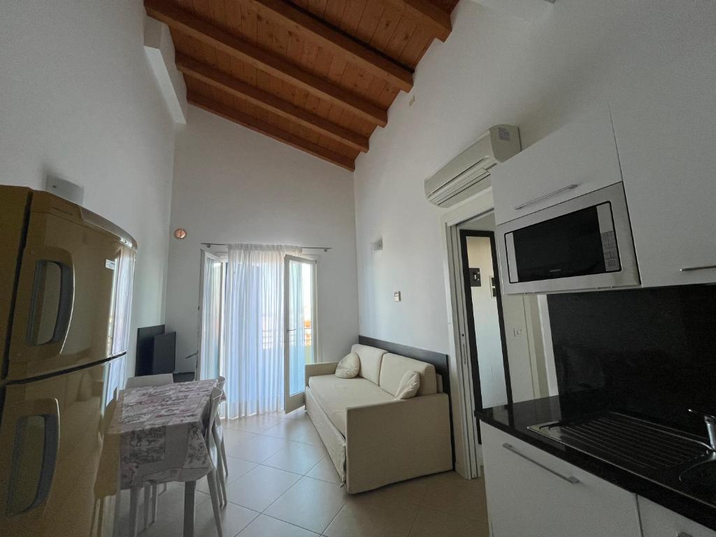 un salon avec un canapé et une télévision dans l'établissement Villaggio Hemingway - Family Aparthotel, à Caorle