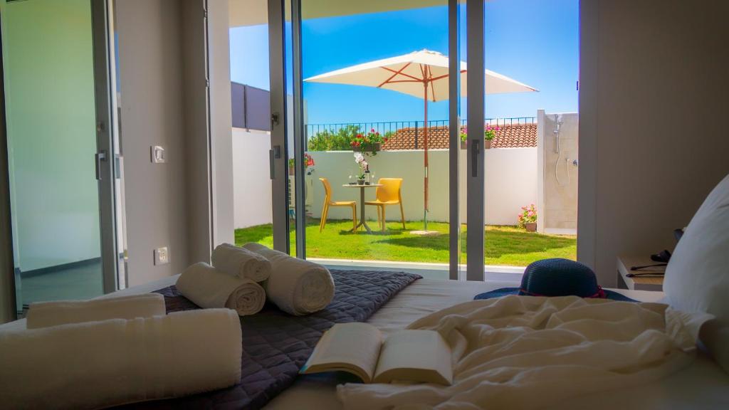 - une chambre avec un lit et une table avec un parasol dans l'établissement Villa Manzoni, à Àrbatax