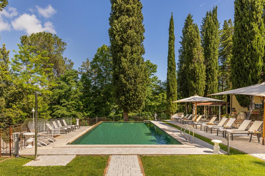 une piscine avec des chaises longues et un parasol dans l'établissement Tenuta Villa Febea, à Chiusi