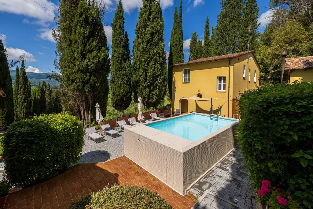 une piscine en face d'une maison arborée dans l'établissement Tenuta Villa Febea, à Chiusi