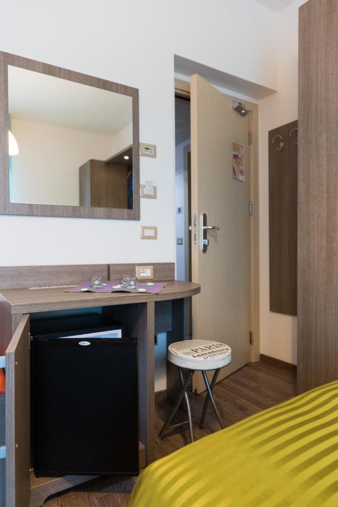 - une chambre avec un bureau, un miroir et un lit dans l'établissement Hotel Miramare, à Pineto