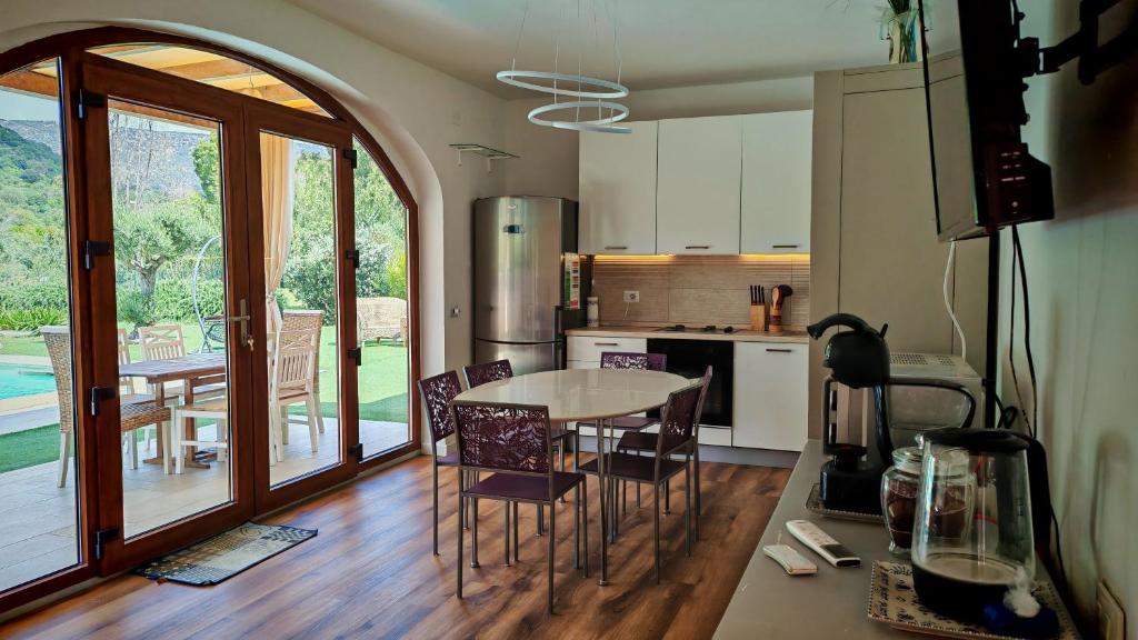 une cuisine avec une table et des chaises dans une pièce dans l'établissement Villa Paola San Teodoro con piscina privata, à Lu Lioni
