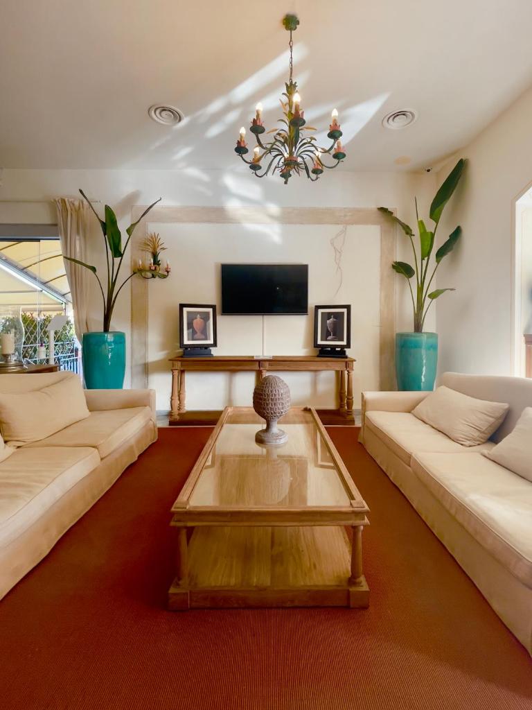 un salon avec deux canapés et une télévision dans l'établissement Hotel La Pigna, à Marina di Pietrasanta 107 autres photos