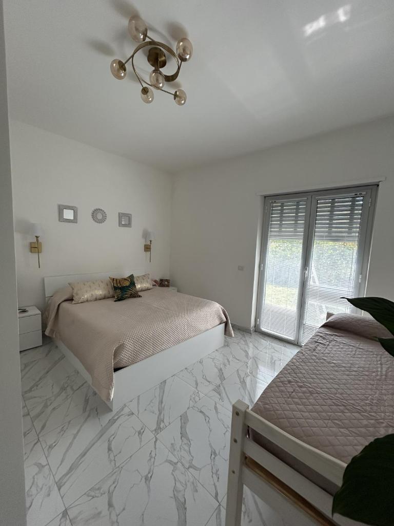 - une chambre blanche avec 2 lits et un lustre dans l'établissement Villa Grazia, à SantʼAgata di Militello 39 autres photos