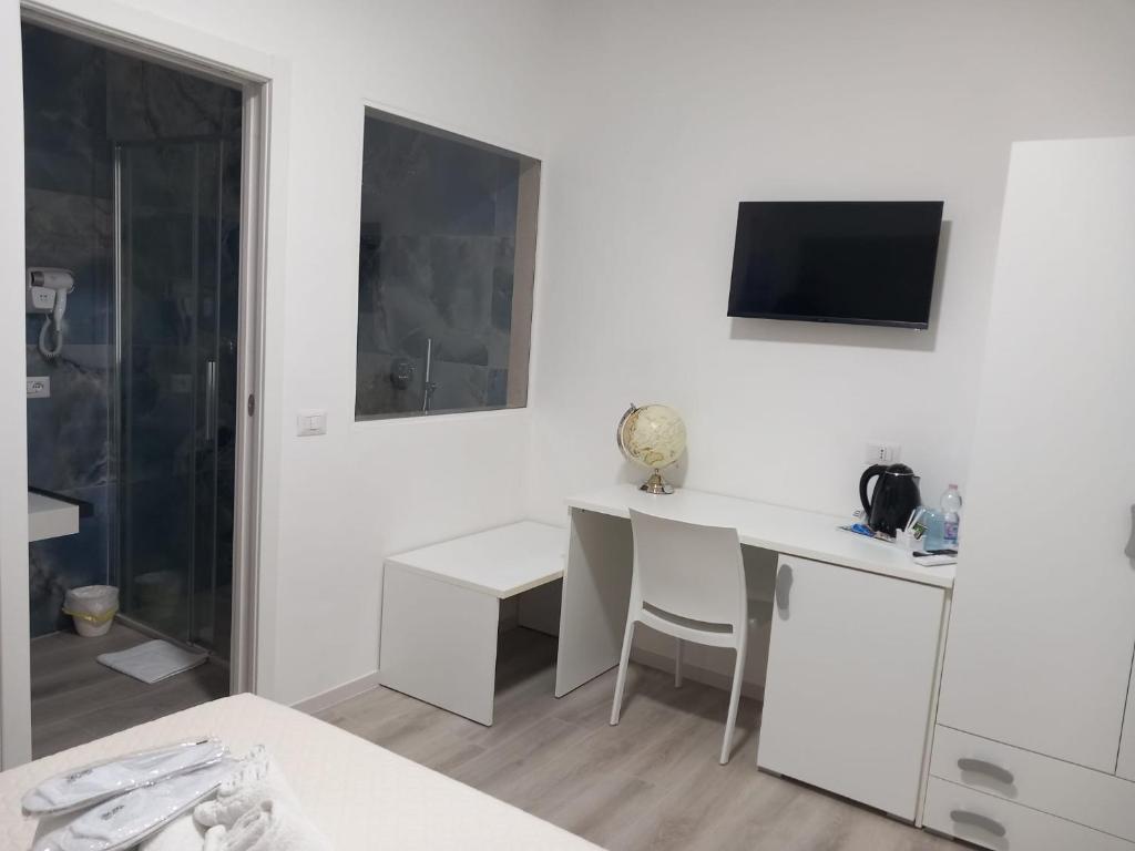 Cette chambre blanche dispose d'un bureau et d'une télévision murale. dans l'établissement Albergo Labotte, à Vieste