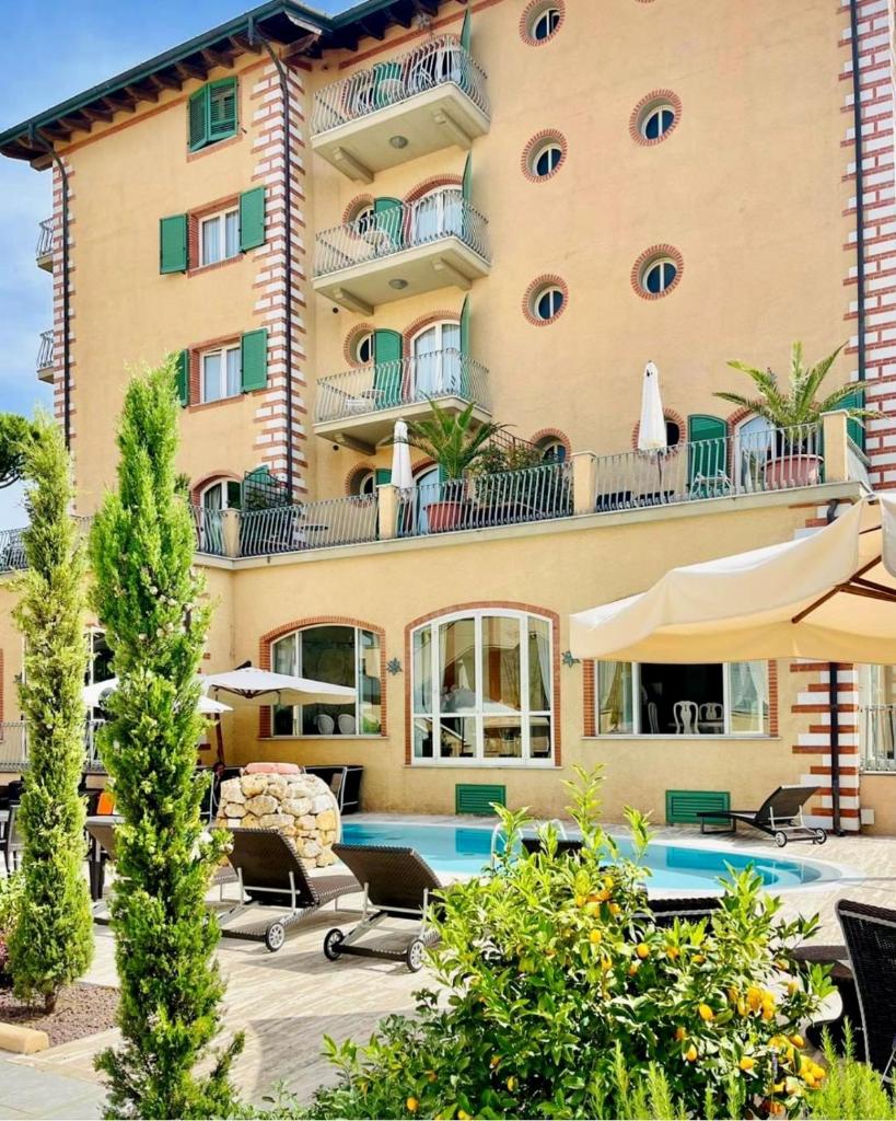 un hôtel avec une piscine devant un bâtiment dans l'établissement Hotel La Pigna, à Marina di Pietrasanta