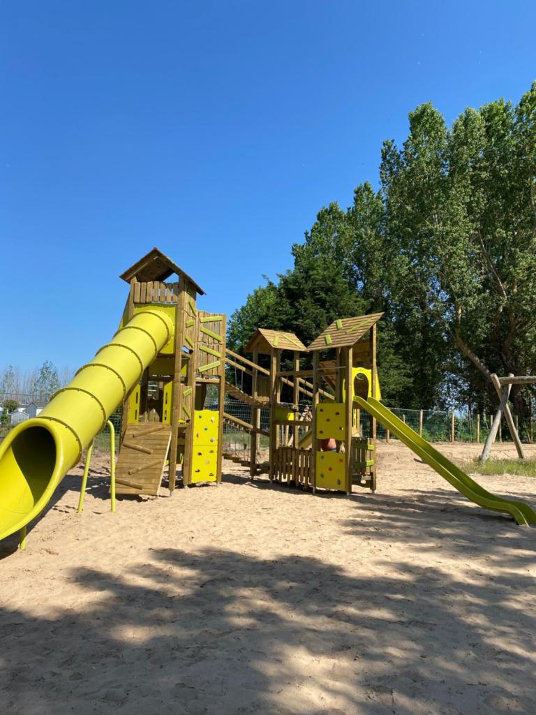 une aire de jeux avec toboggan jaune dans un parc dans l'établissement Domaine Résidentiel de Plein Air Escale du Perthuis, à La Tranche-sur-Mer