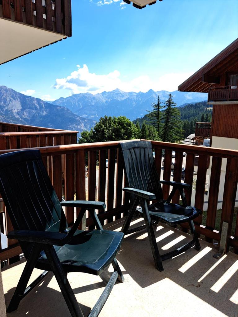 - deux chaises sur un balcon avec vue sur les montagnes dans l'établissement Appartement avec balcon - 2 personnes, à Puy-Saint-Vincent