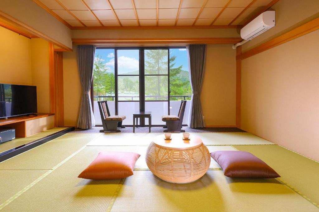 un salon avec une table et une grande fenêtre dans l'établissement TAOYA Kisoji, à Nagiso 35 autres photos