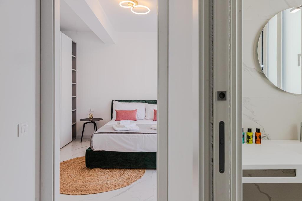 une chambre avec un lit et un miroir dans l'établissement NAHIA Collection Villa, à Campofelice di Roccella