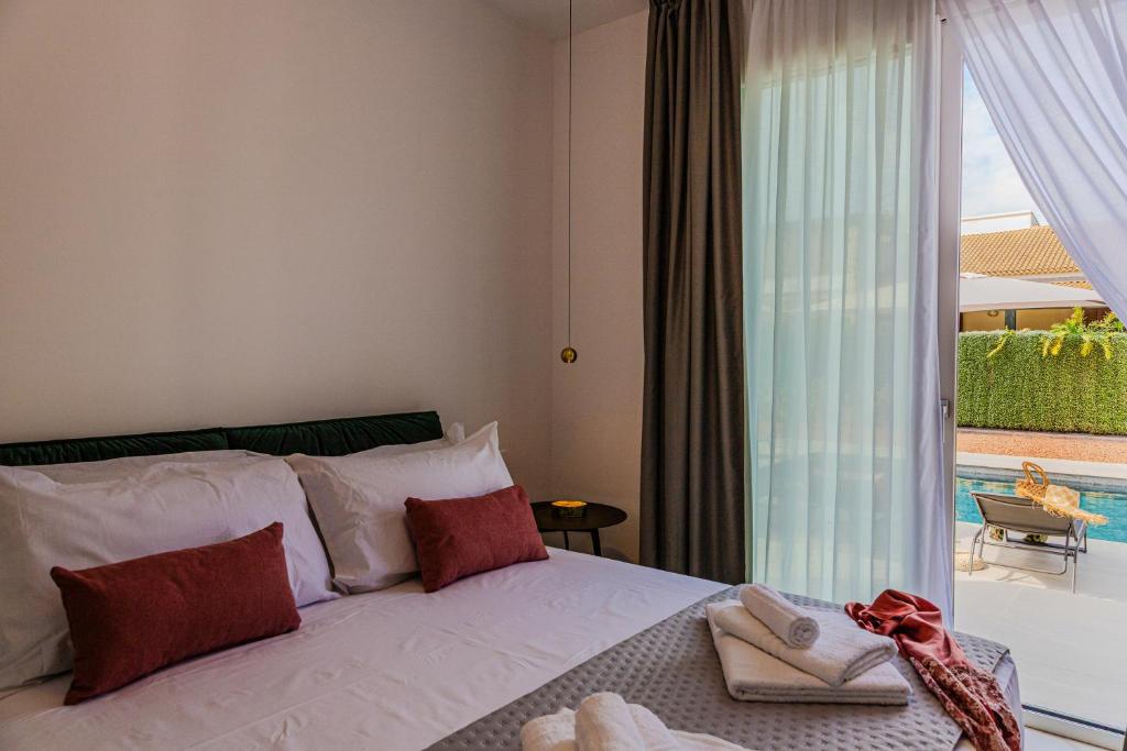 une chambre avec un lit et une grande fenêtre dans l'établissement NAHIA Collection Villa, à Campofelice di Roccella