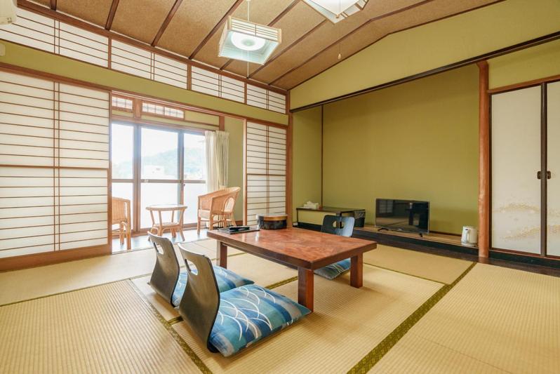 un salon avec une table et un canapé dans l'établissement 熱海来宮の湯 松月, à Atami