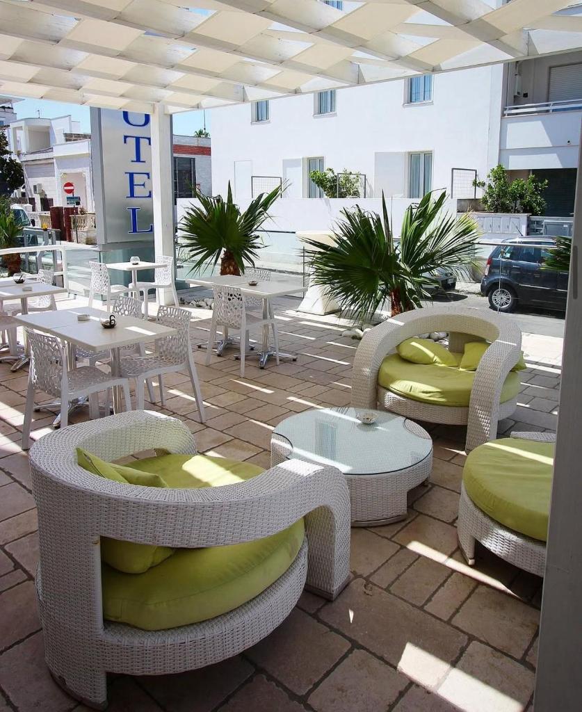 d'une terrasse avec des tables et des chaises blanches. dans l'établissement Hotel Paladini, à Porto Cesareo