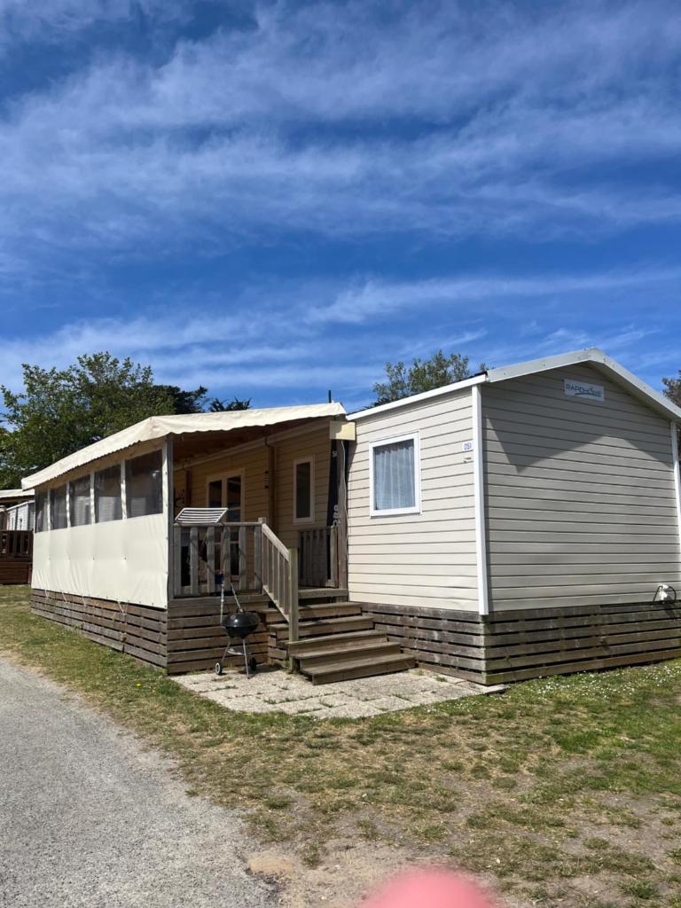 Ce mobile home dispose d'une terrasse couverte et d'un escalier. dans l'établissement Vue Mer, à Quiberon