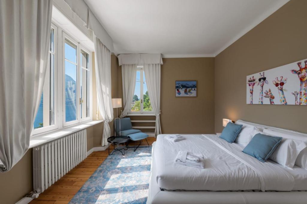 une chambre avec un grand lit et deux fenêtres dans l'établissement Ruby Como Villa with Lake View By Petra Luxury, à Laglio