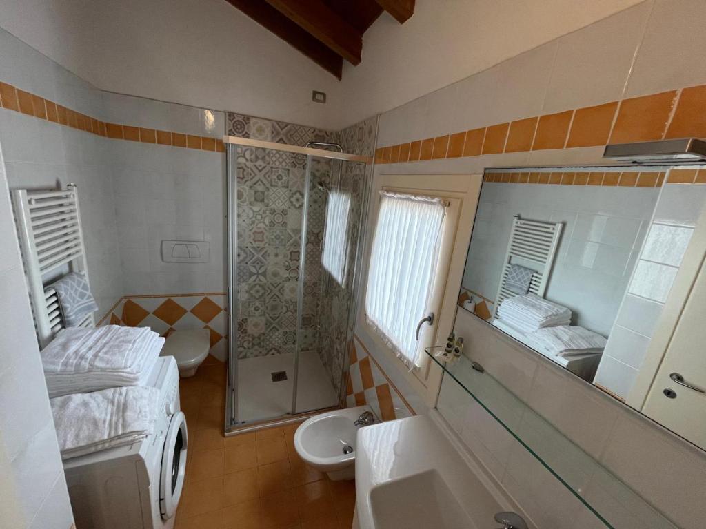 La salle de bains est pourvue d'un lit, d'un lavabo et d'un miroir. dans l'établissement Villaggio Hemingway - Family Aparthotel, à Caorle
