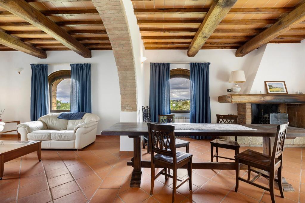 un salon avec une table, des chaises et un canapé dans l'établissement Podere Beccalorzo con piscina, à San Donato in Poggio