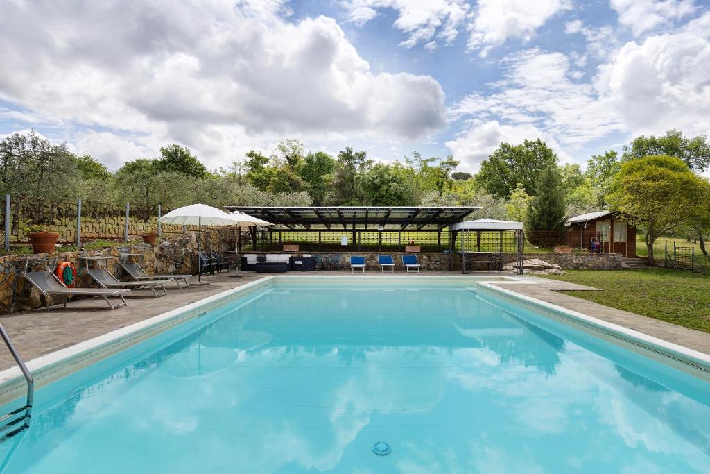 une piscine dans une cour avec une maison dans l'établissement Podere Beccalorzo con piscina, à San Donato in Poggio