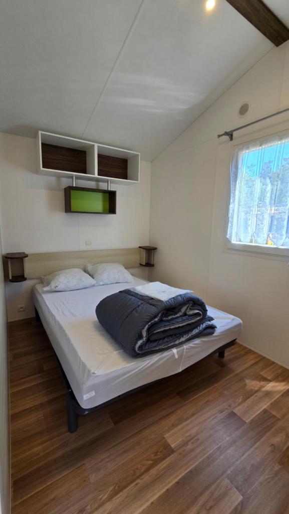 une chambre avec un lit dans une pièce dans l'établissement Camping les Mancellieres, à Avrillé