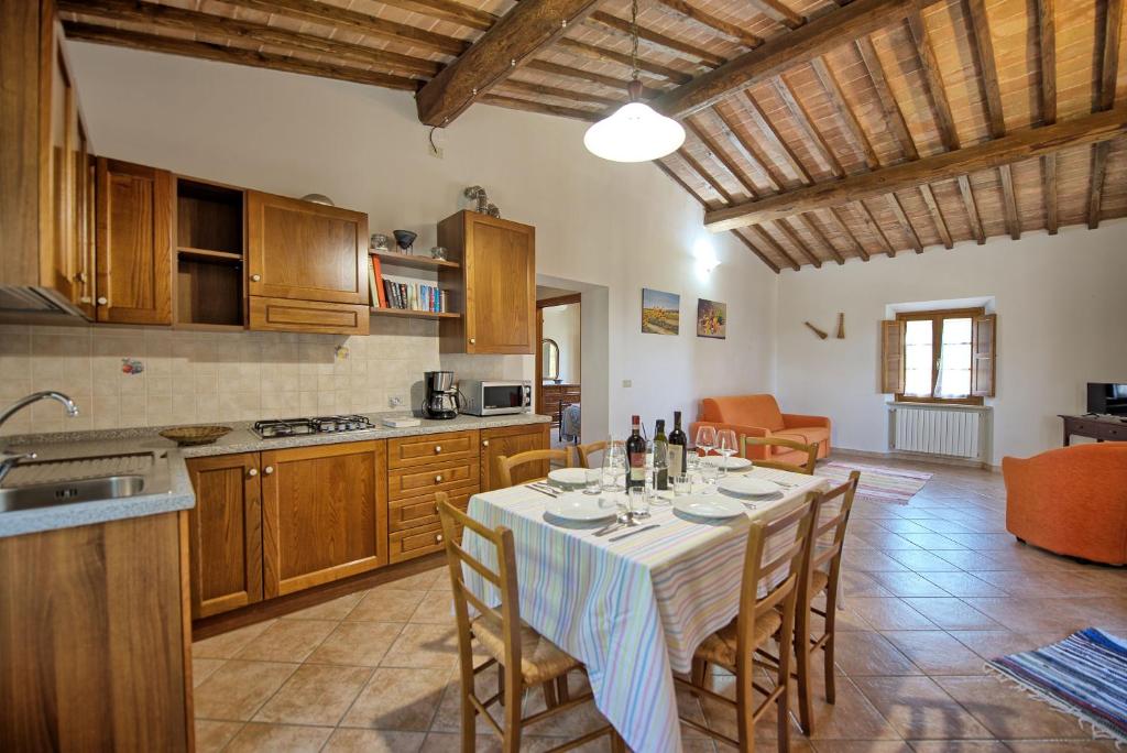 une cuisine et une salle à manger avec une table et des chaises dans l'établissement Villa Picchio by PosarelliVillas, à Volterra