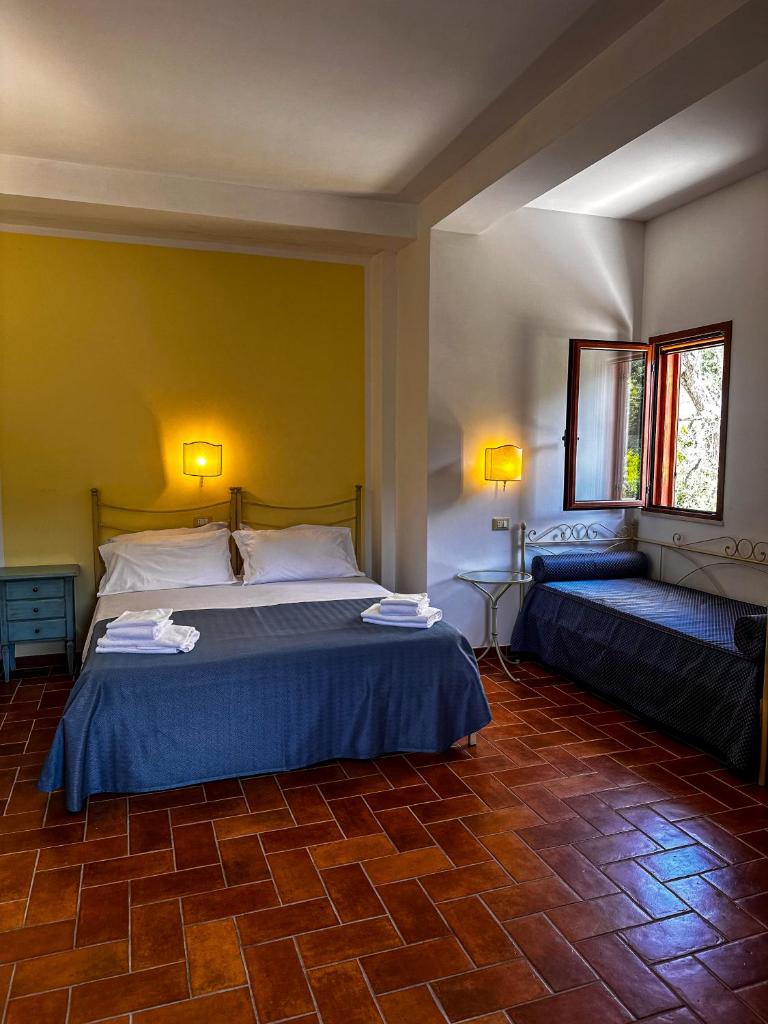 - une chambre avec 2 lits et un mur jaune dans l'établissement Villa Poggio di Luna con piscina privata, à Peschici