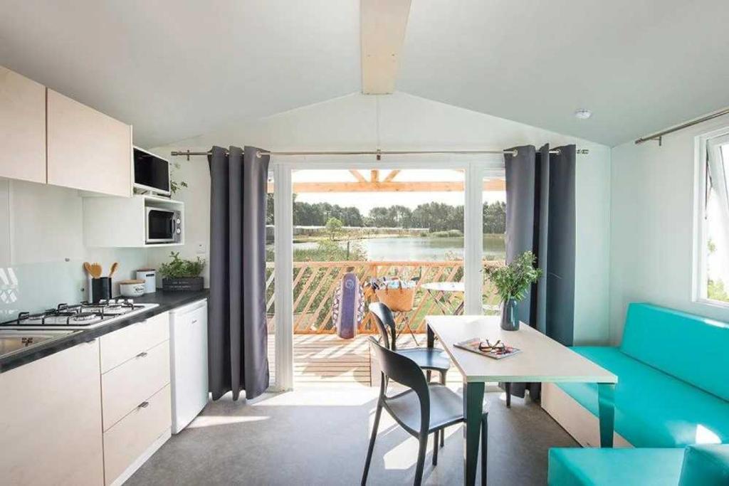 une cuisine avec une table et une salle à manger avec vue dans l'établissement Camping 3 étoiles - Piscine - eebeae, à Mondragon