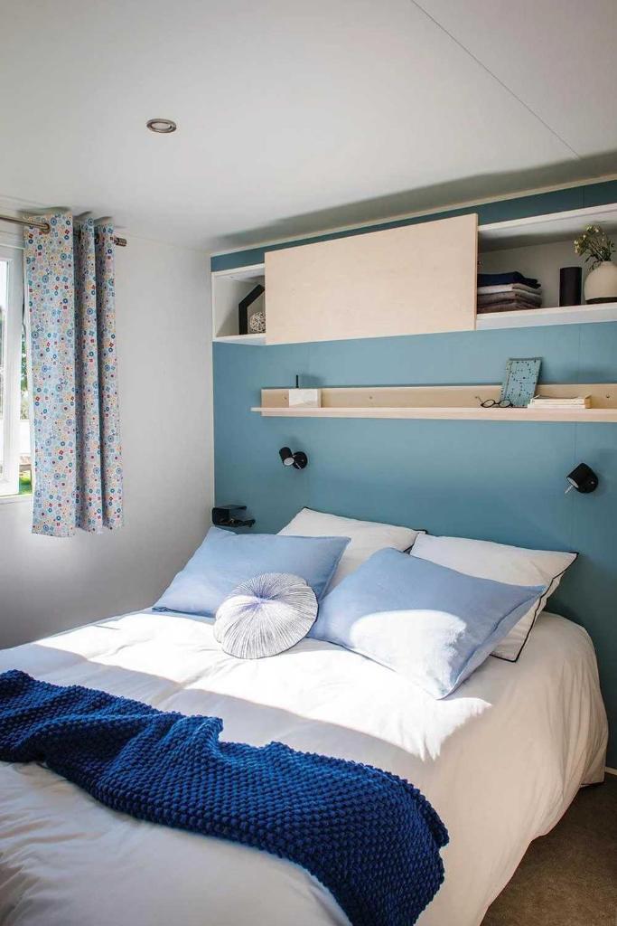 un lit avec des oreillers bleus et blancs dessus dans l'établissement Camping 3 étoiles - Piscine - eebeae, à Mondragon