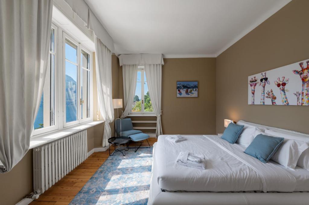 une chambre avec un grand lit et deux fenêtres dans l'établissement Ruby Como Villa with Lake View By Petra Luxury, à Laglio 82 autres photos