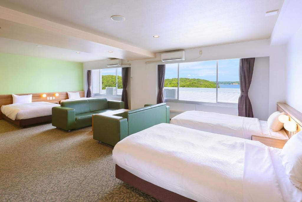 une chambre d'hôtel avec deux lits et une grande fenêtre dans l'établissement Ooedo Onsen Monogatari Premium Iseshima, à Shima 37 autres photos