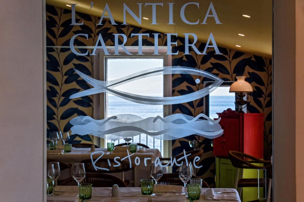 une enseigne dans un restaurant avec une table devant une fenêtre dans l'établissement Ravello Art Hotel Marmorata, à Ravello