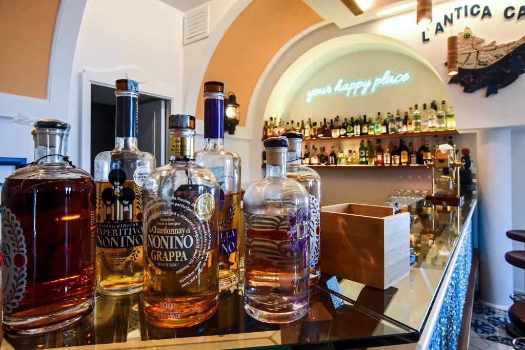 un groupe de bouteilles d'alcool assises sur un bar dans l'établissement Ravello Art Hotel Marmorata, à Ravello