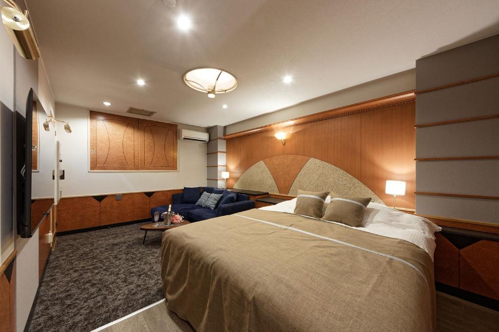 une chambre d'hôtel avec un lit et un canapé dans l'établissement ホテル Ano, à Kanuma 4 autres photos