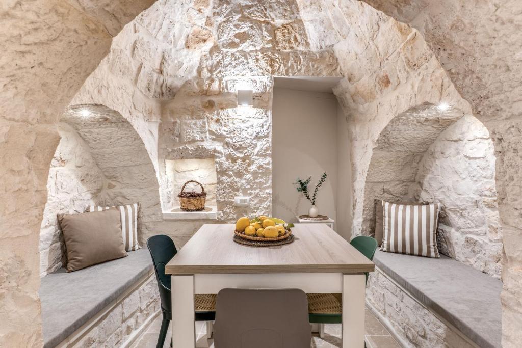 une salle à manger avec une table avec un bol de fruits dessus dans l'établissement Trullo The Cove, à Ceglie Messapica
