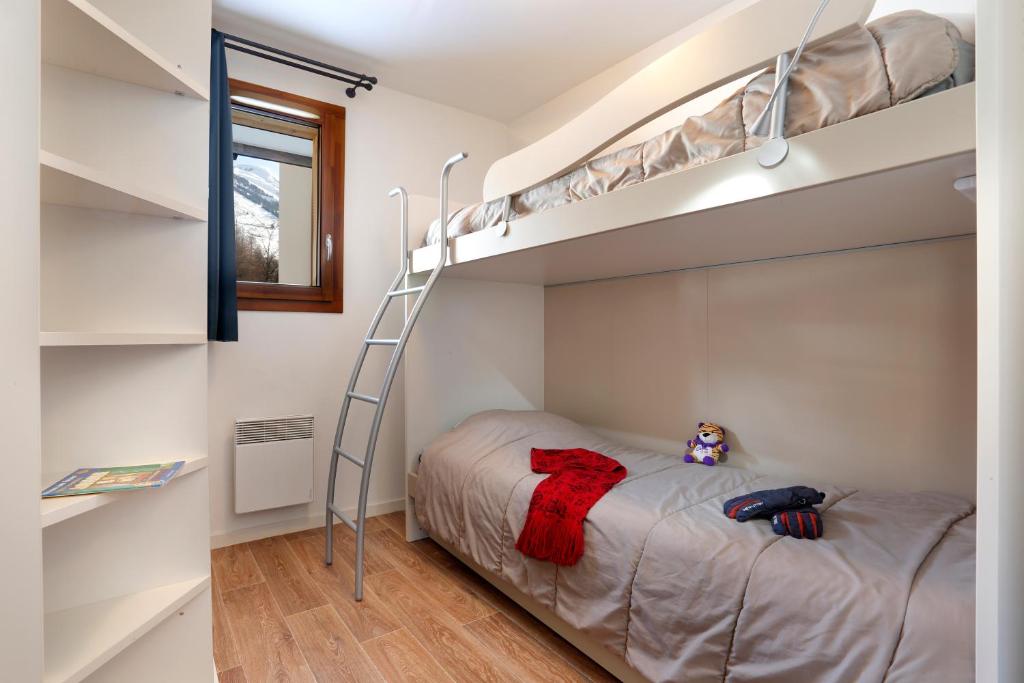 une chambre avec un lit superposé avec une échelle dans l'établissement Vacancéole - Au Coeur des Ours, à Les Deux Alpes 21 autres photos
