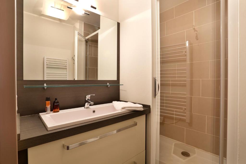 une salle de bain avec un lavabo et un miroir dans l'établissement Vacancéole - Au Coeur des Ours, à Les Deux Alpes