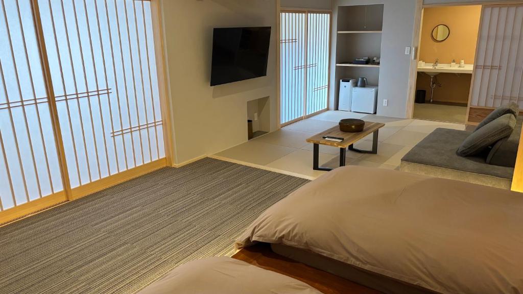Cet appartement comprend une chambre avec un lit, une télévision et un salon. dans l'établissement Kazuraya, à Miyoshi