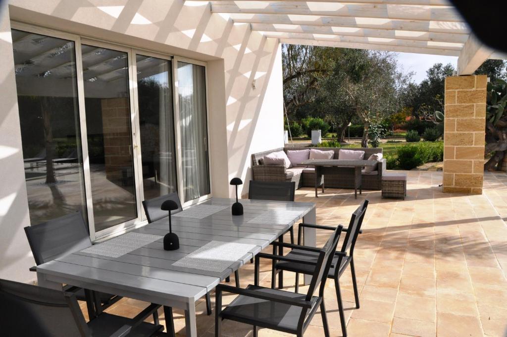 un patio avec une table, des chaises et un canapé dans l'établissement Oasi Temerano, à Seclì