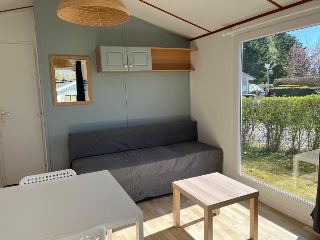 une petite pièce avec un lit et une fenêtre dans l'établissement Camping-Caravaning de la Mollière, à Groffliers
