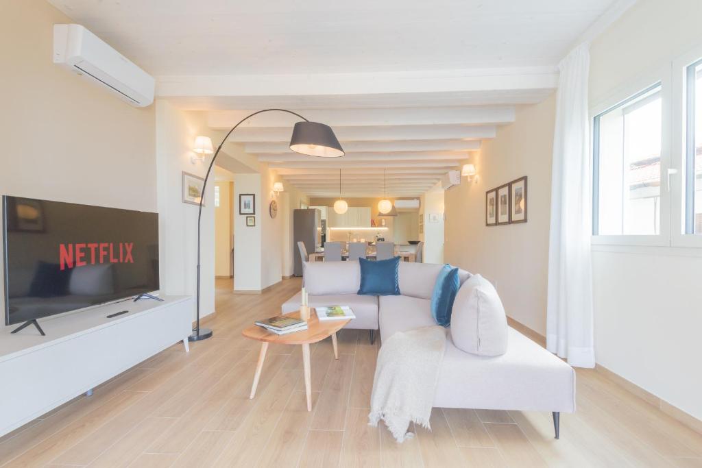 un salon avec un canapé blanc et une télévision dans l'établissement Villa Cosima in Bellagio with Private Pool by Rent All Como, à Bellagio 33 autres photos