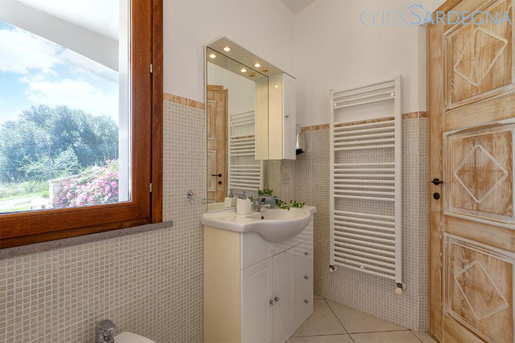 une salle de bain avec un lavabo et un miroir dans l'établissement Villa Janas Luxury Villa surrounded by large park, swimming pool, parking and Wifi, à Alghero